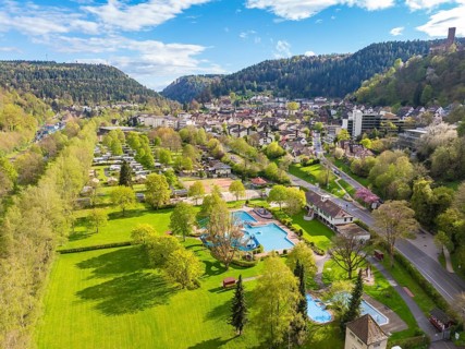 Green parkland with pool and town in a mountainous setting, Bad Liebenzell, Calw district, Black