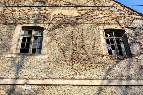 Façade with 2 smashed wooden windows on the gable, former mill of Töpeln, Döbeln, Saxony, Germany,