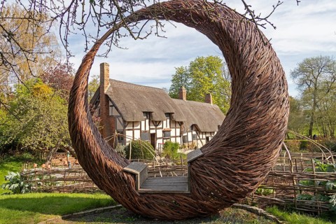 Anne Hathaway's Cottage framed by a round wicker seat, Shottery, Stratford-upon-Avon, Warwickshire,