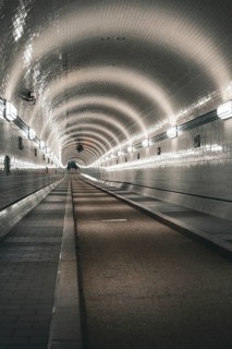 Long, illuminated tiled tunnel with symmetrical curves, old Elbe tunnel, Hamburg, Germany, Europe