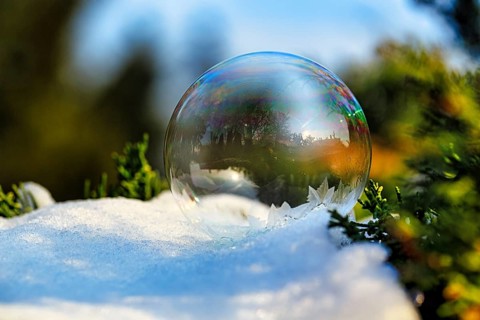 Freezing soap bubble in the snow, frost in the garden, ice crystals, cold winter weather, winter