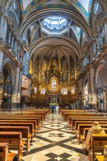 Tourists admiring the interior of santa maria de montserrat basilica, located in the montserrat