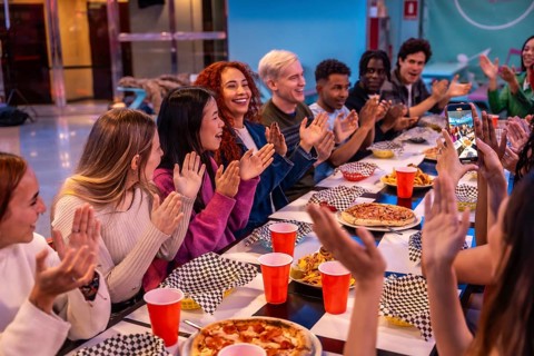 Young diverse people celebrating and having fun together at a bowling alley restaurant, enjoying