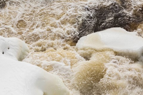 Packed snow with ice and strong water current released through water flow control gates on
