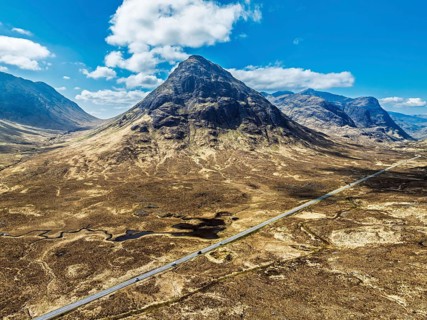 Buachaille Etive Beag and Three Sisters in Glencoe over Moors and Road A82 from a drone, Highlands,