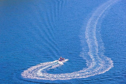 Motorboat that has made a turn on the sea with white wake pattern, Crozon peninsula, Bretagne,