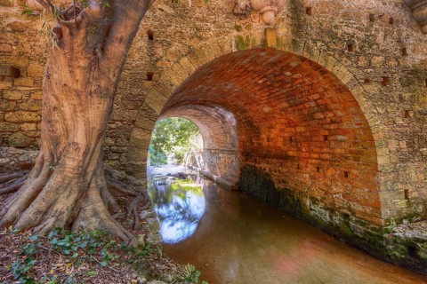 Stone tunnel with tree and quiet river, pure nature, Rodini Park, municipal park, Rhodes Town,