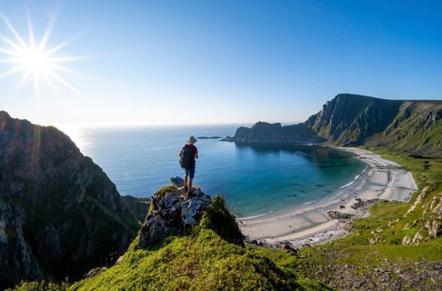 Mountaineer with view of coastal landscape, steep coast with summit Måtind or Måtinden, Høyvika
