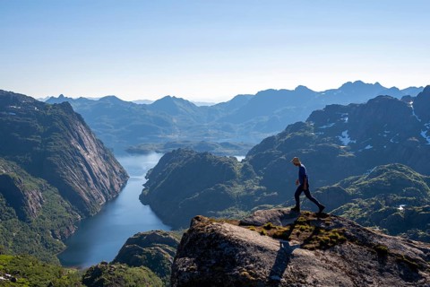 Mountaineer, young man in front of mountain landscape, fjord Trollfjord and mountains, hike to