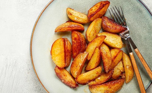Fried potato slices, on a plate, top view, homemade, no people