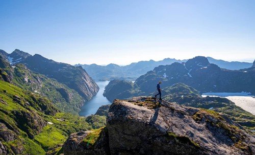 Mountaineer, young man hiking in front of mountain landscape, fjord Trollfjord and mountains, hike