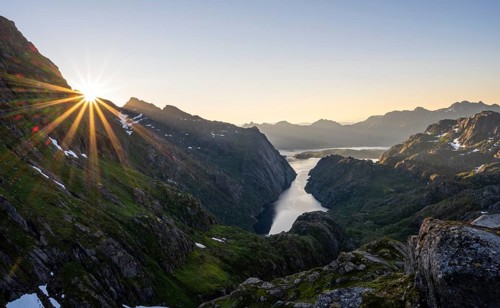 Picturesque mountain landscape at sunrise with sun star, fjord Trollfjord and Raftsund, hike to