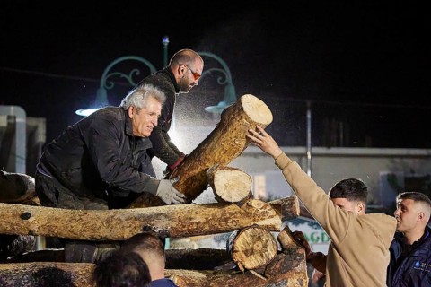 Men working together at night to build a large pile of wood for a fire, Easter fire Psinthos, Holy