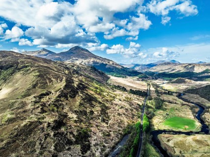 Farms and Mountains over River Dochart and Road A85 from a drone, Perthshire, Scotland, UK