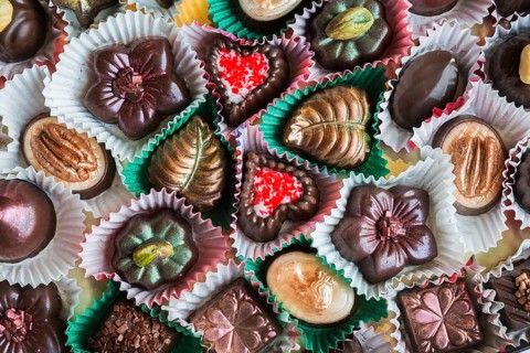 Top view and close-up of hand made mixed flavor fancy fine delicious chocolates in opened chocolate