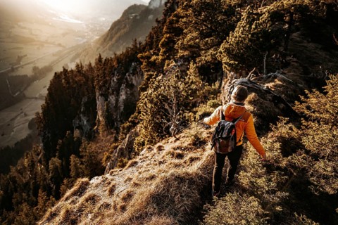 Hiker in the Allgäu at sunset in spring on the Zirmgrat near Pronten in the Allgäu