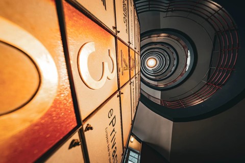 Dramatic view upwards through a spiral staircase with warm light, SPRINKENHOF, Hamburg, Germany,
