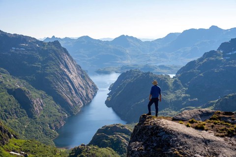 Mountaineer, young man in front of mountain landscape, fjord Trollfjord and mountains, hike to