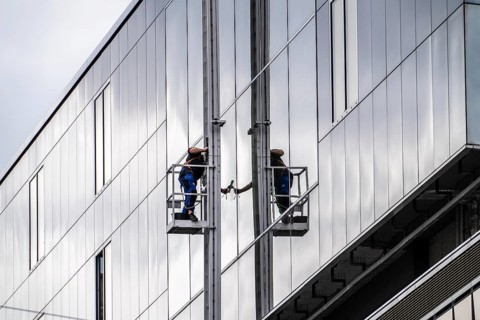 Window cleaner, facade cleaning, window cleaning, on a glass facade in Düsseldorf, ladder cage from