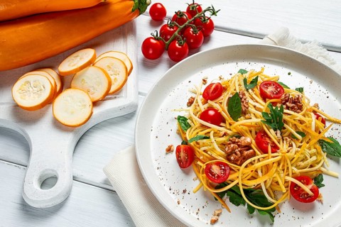 Yellow zucchini salad, with cherry, vegetarian food, sliced into strips, homemade
