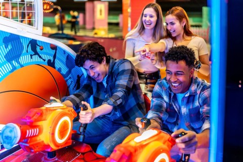 Young adults enjoying time together while playing arcade games in a vibrant bowling alley, filled