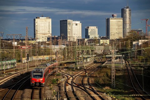 Train on the tracks west of Essen central station, city centre skyline, regional express train,