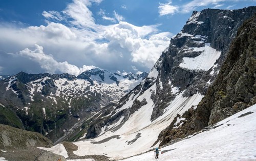 Mountaineer hiking in a snowfield, Nördliche Mörchnerscharte, behind mountain peak Kleiner Mörchner