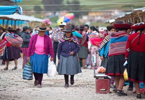 Peruvian woman with traditional skirts and hats at the indigenous market in Chinchero, Cusco