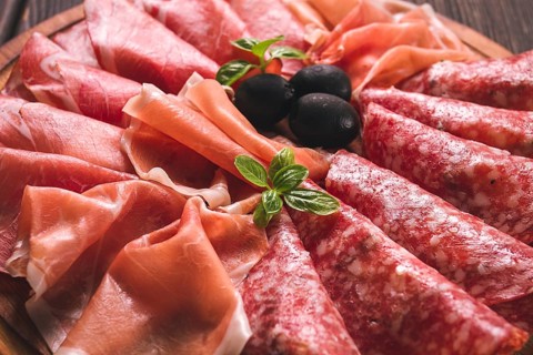 Assortment, sliced meat appetizer, prosciutto, salami and ham, with olives, breakfast, top view,