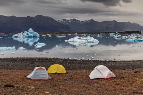 Tents in front of glacier lagoon, icebergs, camping, mountains, cloudy, winter, Jökulsarlon,