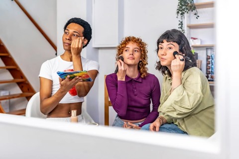 View from a mirror of non binary and gay friends making up at home