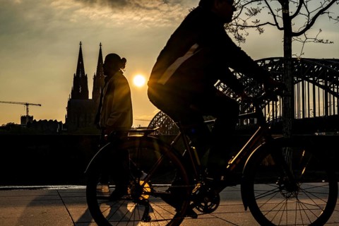 Silhouettes of people in late sunlight, on the Deutz riverbank, right bank of the Rhine, cyclists,