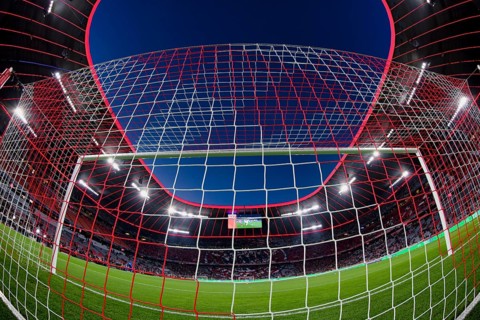 Overview, interior, floodlit match, behind-the-goal perspective, goal net, blue hour, fisheye shot,