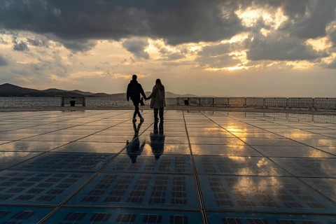 Couple on the solar installation Greeting to the sun at sunset, Zadar, Croatia, Europe
