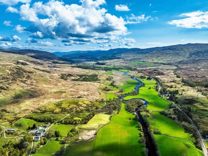 Farms and Mountains over River Dochart and Road A85 from a drone, Perthshire, Scotland, UK