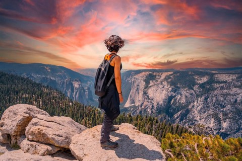 A young woman trekking at Sentinel Dome Lookout in Yosemite National Park looking at El Capitan