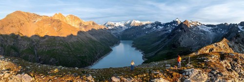 Hikers enjoying the alpine panorama at Lac de Dix, sunset in the mountains, reservoir, Valais Alps,