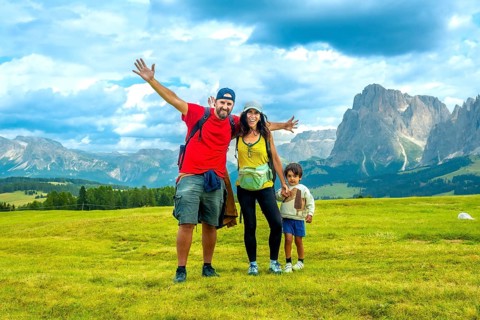 Happy family enjoying summer vacation in the italian alps, embracing the breathtaking scenery of