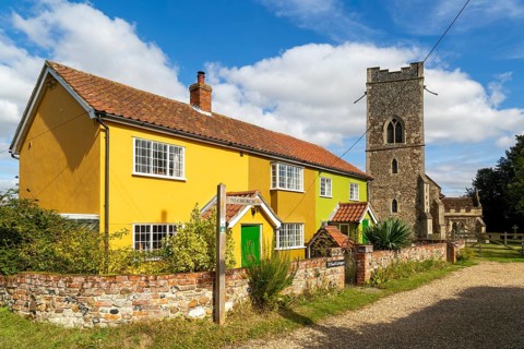 Historic cottages next to village parish church of All Saints, Rede, Suffolk, England, UK