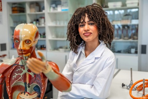 Confident medical student learning human anatomy using anatomical model in a university laboratory