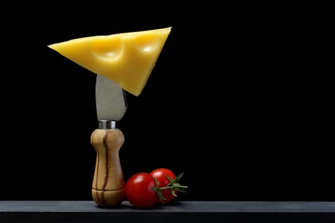 A piece of Swiss Emmental cheese on a cheese knife