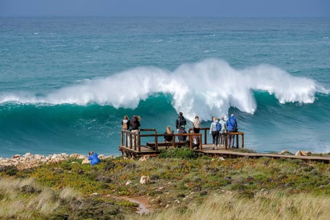 Carrapateira, Algarve, Portugal - Tourists on a viewing platform marvel at the roaring surf and