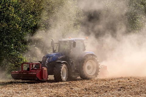 Tractor with plough digging up dried-out soil, large cloud of dust, dust, dry, field, soil,