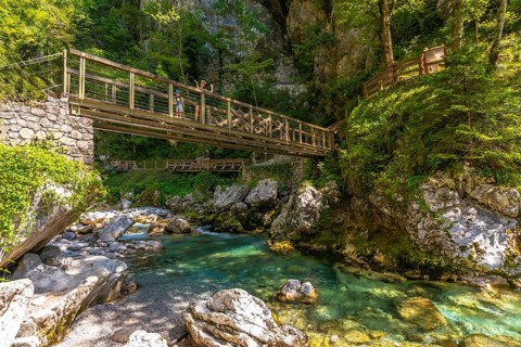 Tourists walking on a wooden bridge over tolminska river in the tolmin gorges, triglav national