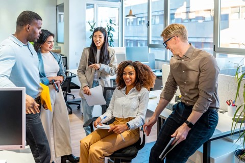 Diverse colleagues engaging in teamwork, sharing ideas, and working together in a modern coworking