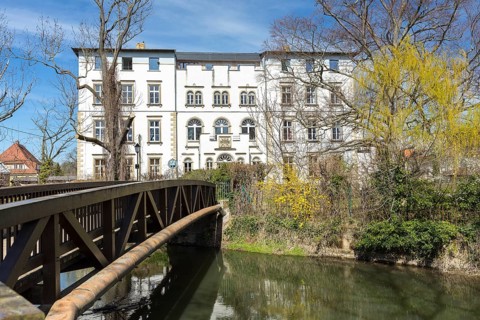 Park view of Lützschena Castle with castle bridge and White Elster, Leipzig, Saxony, Germany,