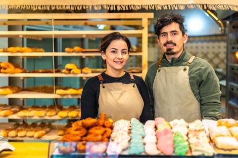 Portrait of male and female latin young coworkers in an artisan bakery shop