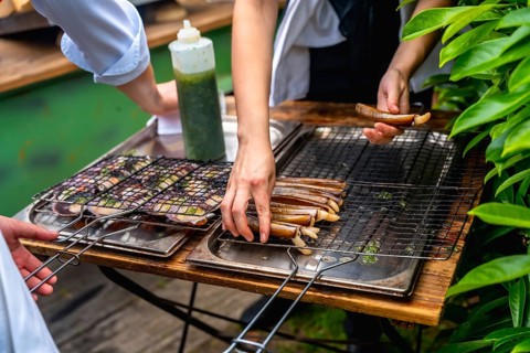 Chefs grilling seafood in an outdoor setting, preparing dishes for a wedding reception, with fresh