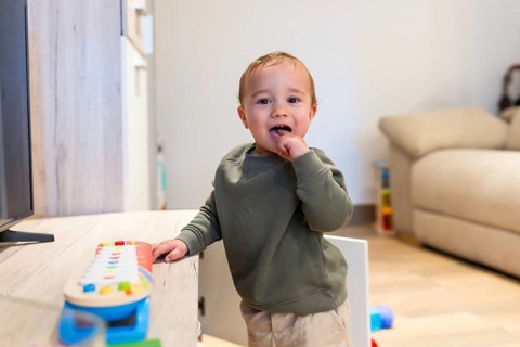 Curious toddler engaging with colorful musical toy, exploring sounds and developing musicality in a