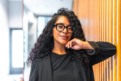 Portrait of a confident and cheerful latin businesswoman with long curly hair and formal elegant